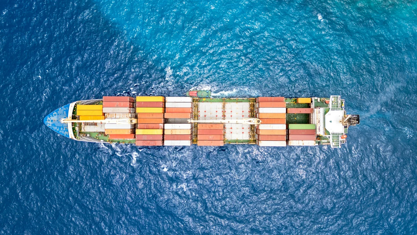 Vista aérea de um navio cargueiro transportando contêineres.