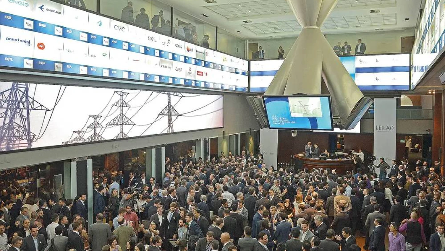 Público reunido no salão da bolsa brasileira, em São Paulo, cercado por painéis eletrônicos.